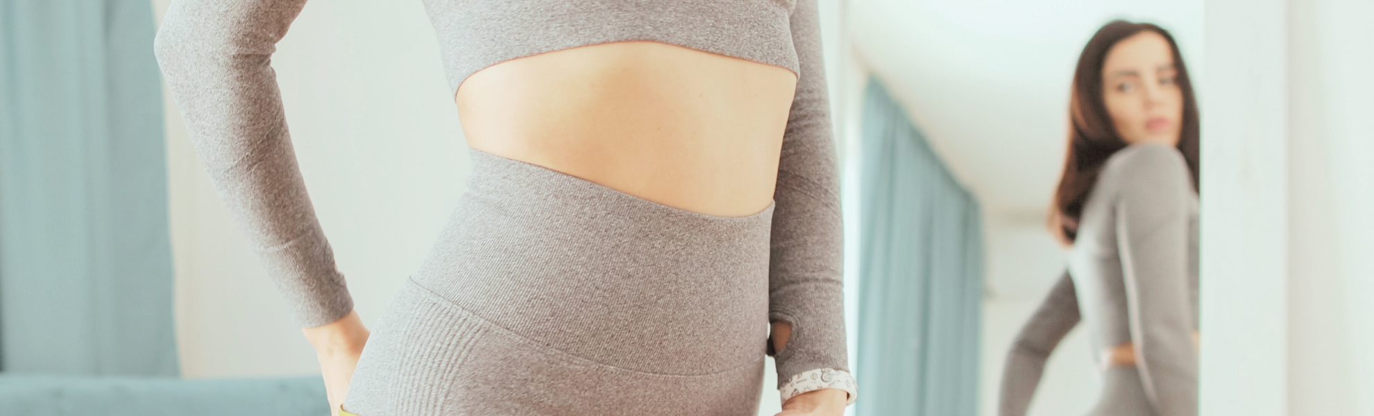 woman reviewing waist in mirror